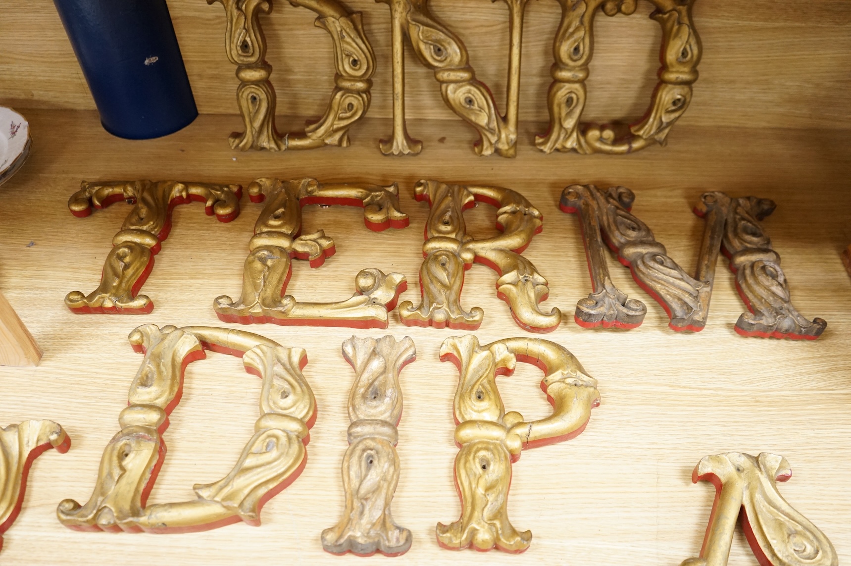 A quantity of decorative carved, painted and gilt carnival letters, each approximately 23cm high